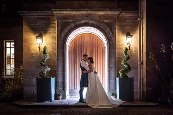 Bride and groom kiss outside main entrance